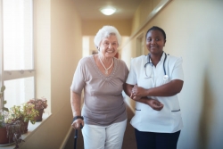 caring female nurse assisting a senior patient to walk.